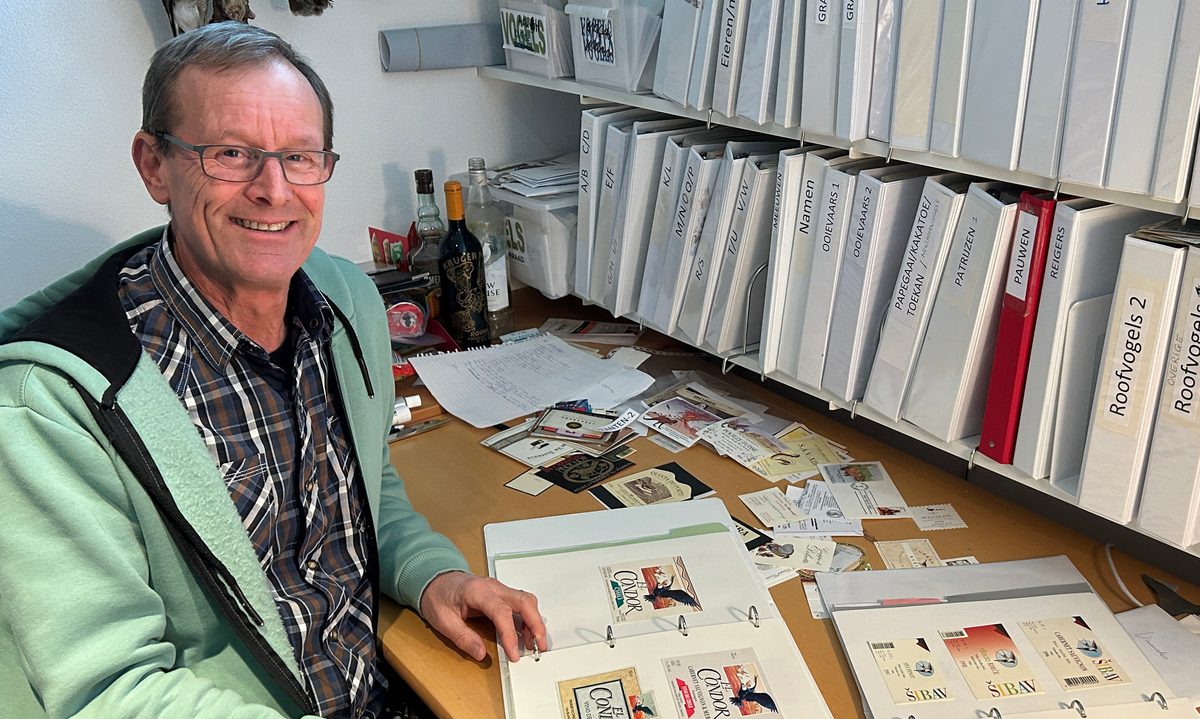 Mike Hirschler aan zijn bureau met mappen dranketiketten